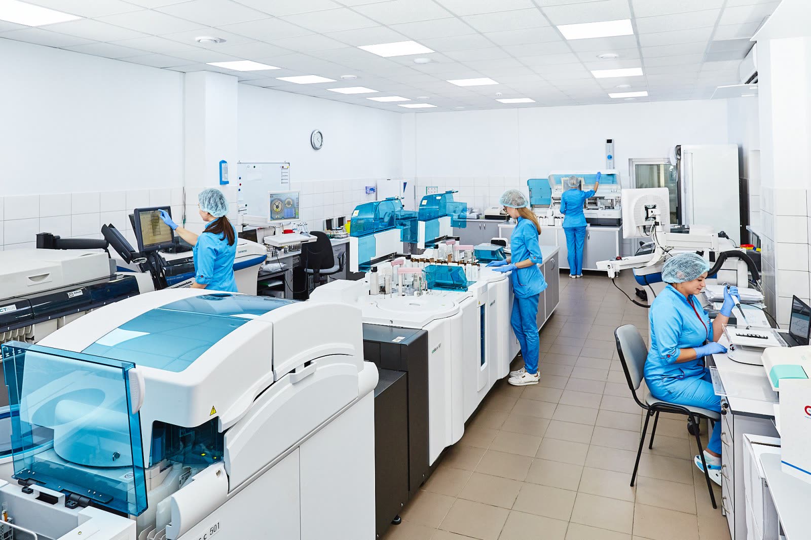 Scientists working with analysers in a clinical laboratory